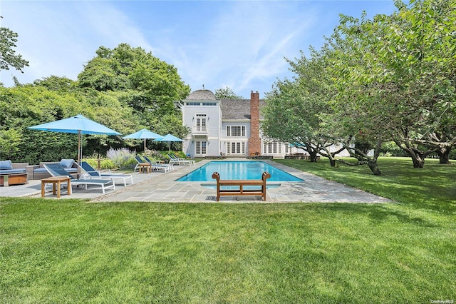 view of pool featuring a lawn and a patio