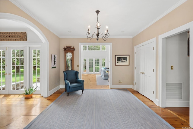 unfurnished room with light hardwood / wood-style flooring, a healthy amount of sunlight, and an inviting chandelier