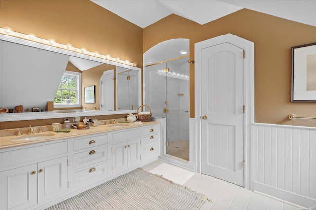 bathroom with vanity, vaulted ceiling, tile patterned floors, and a shower with shower door