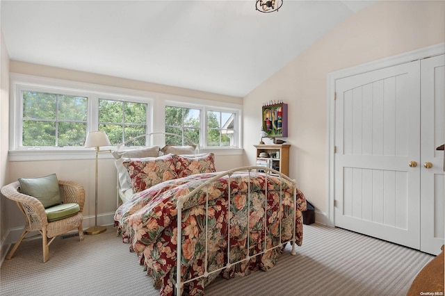 bedroom with carpet floors and lofted ceiling