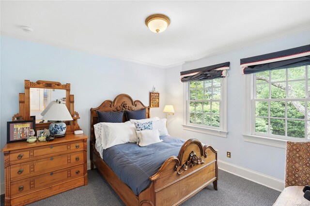 bedroom with dark carpet and ornamental molding