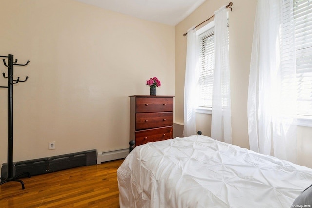 bedroom featuring hardwood / wood-style flooring and a baseboard radiator