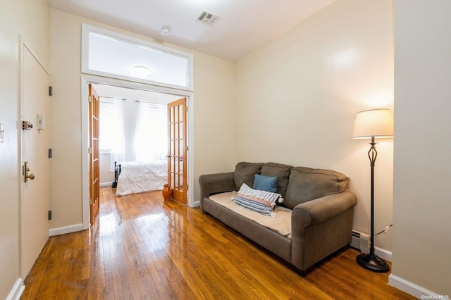 sitting room with hardwood / wood-style floors and a baseboard radiator