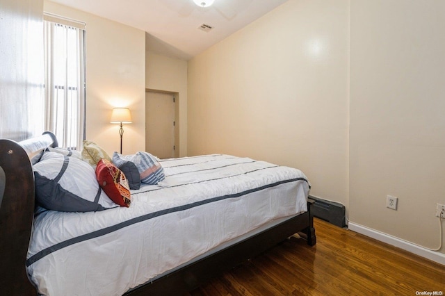 bedroom with vaulted ceiling, ceiling fan, and dark wood-type flooring