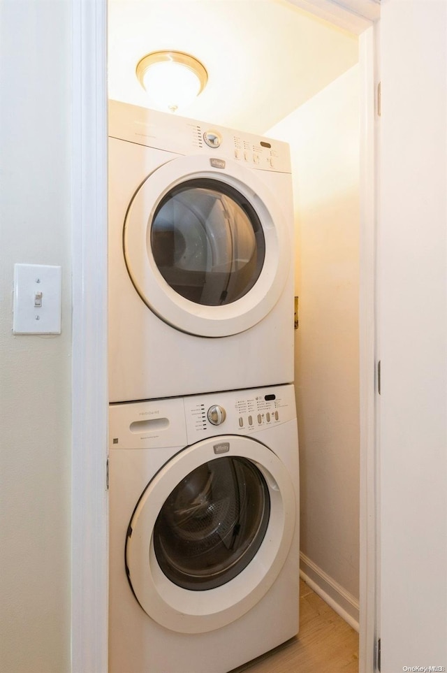 laundry area featuring light hardwood / wood-style floors and stacked washing maching and dryer