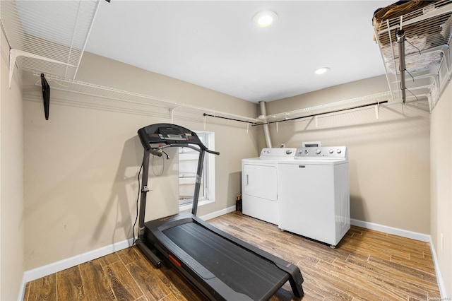 exercise room featuring hardwood / wood-style floors and washing machine and dryer