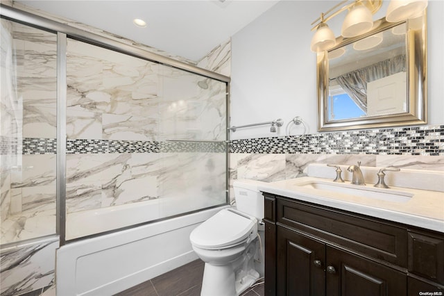 full bathroom featuring vanity, toilet, shower / bath combination with glass door, and tile walls