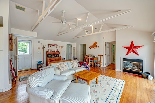 living room featuring hardwood / wood-style flooring, vaulted ceiling, and ceiling fan