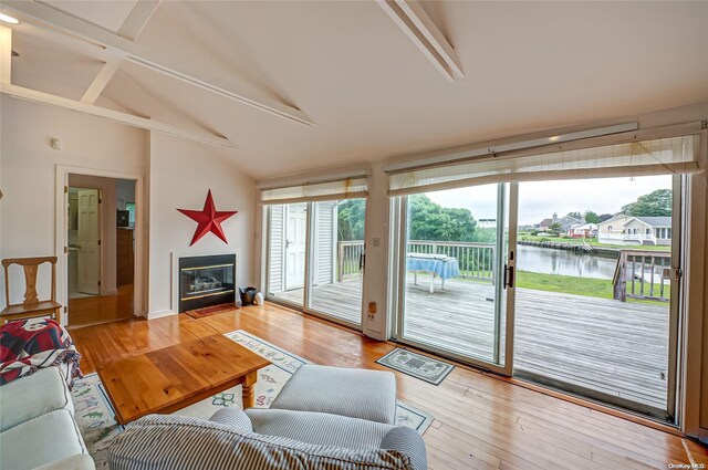 4 Landing Ln, Southampton, NY 11968 - living area with a water view, a glass covered fireplace, and light wood-style floors