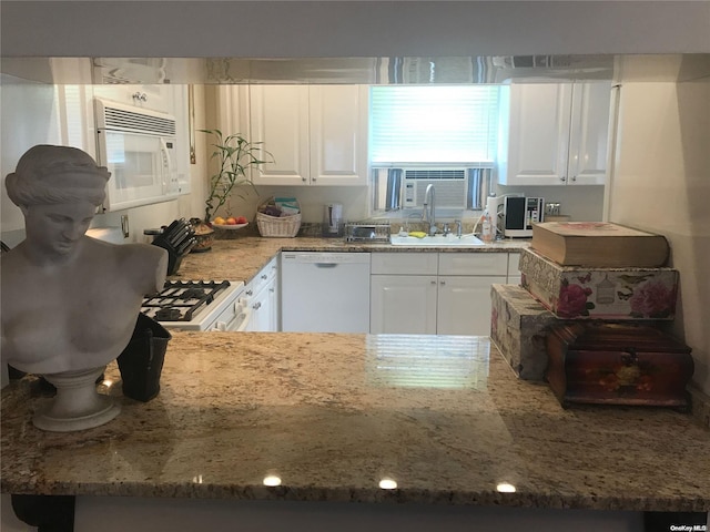 kitchen featuring light stone countertops, white appliances, white cabinetry, and sink