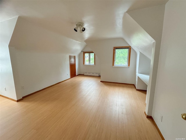 bonus room with lofted ceiling, light wood-type flooring, and baseboard heating