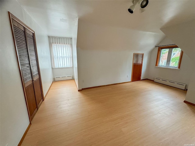 bonus room featuring light hardwood / wood-style flooring, a baseboard radiator, and lofted ceiling