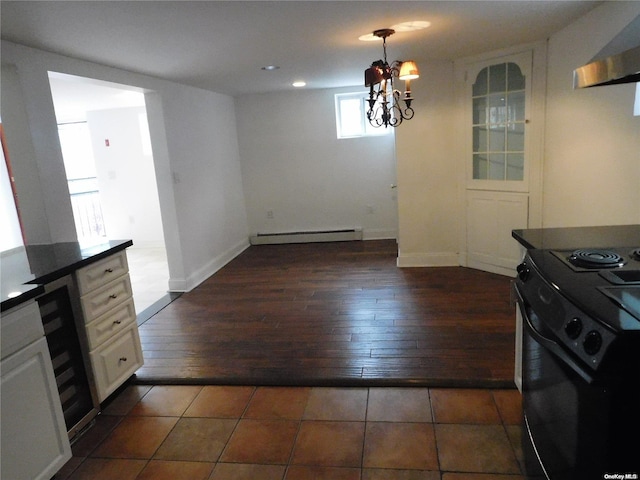 kitchen featuring dark wood-type flooring, exhaust hood, white cabinets, black electric range, and baseboard heating