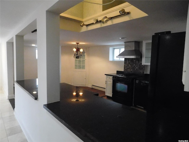 kitchen featuring wall chimney range hood, baseboard heating, white cabinets, light tile patterned floors, and black appliances