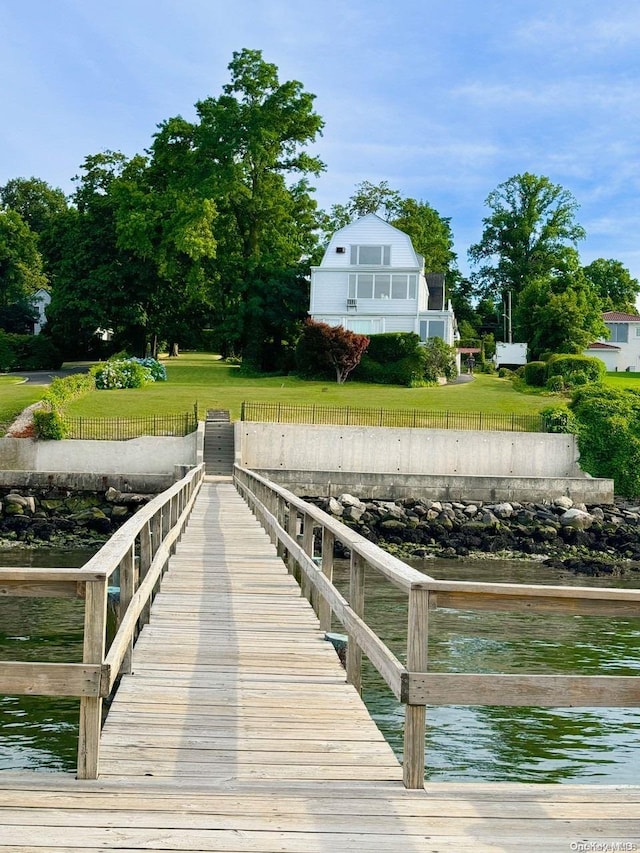 dock area featuring a lawn and a water view