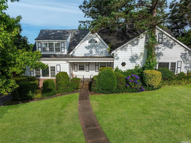 cape cod house featuring a front yard