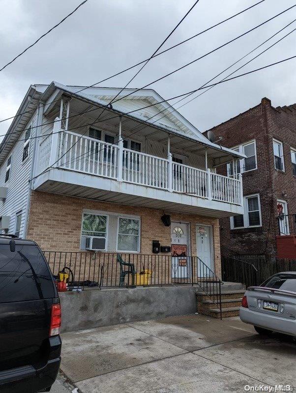 view of front of home with cooling unit and a balcony