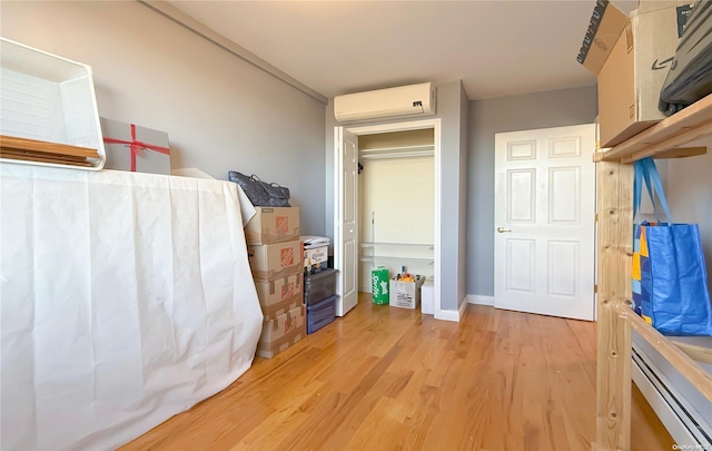 interior space with a wall mounted air conditioner and light hardwood / wood-style flooring