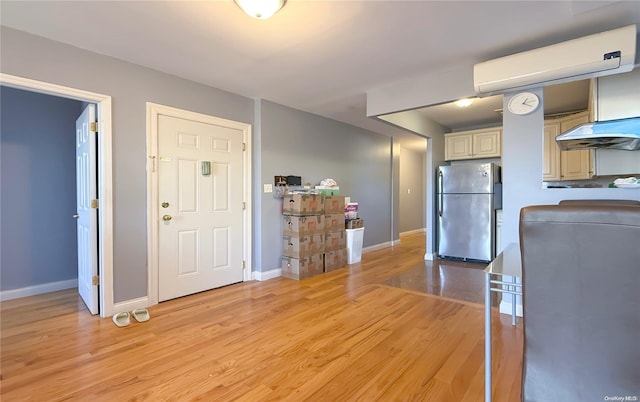 kitchen with cream cabinetry, light hardwood / wood-style floors, and stainless steel refrigerator