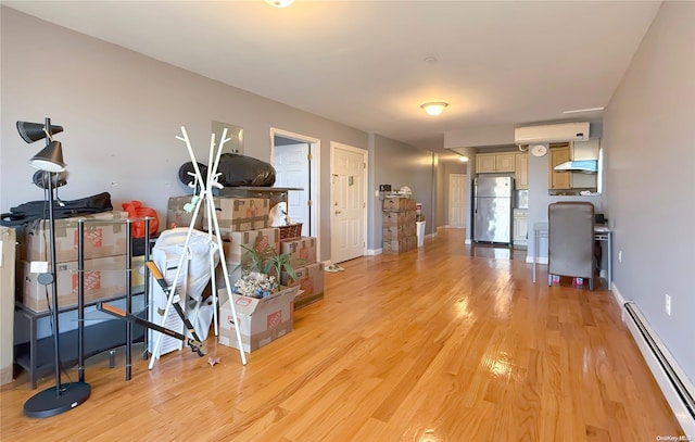 interior space featuring light wood-type flooring, baseboard heating, and a wall unit AC