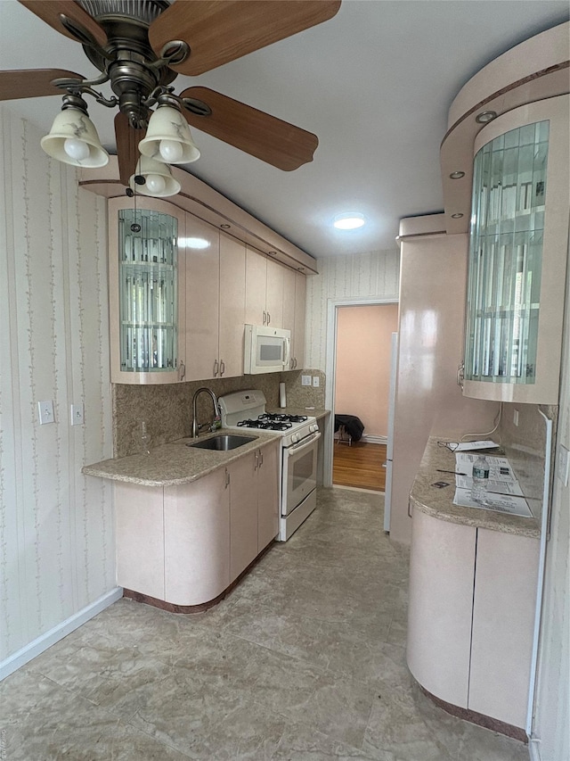 65-38 Booth St Unit 2F, Rego Park, NY 11374 - kitchen with white appliances, a sink, light countertops, ceiling fan, and wallpapered walls