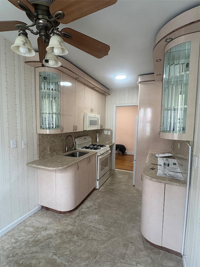 65-38 Booth St Unit 2F, Rego Park, NY 11374 - kitchen featuring white appliances, a sink, light countertops, wallpapered walls, and a ceiling fan