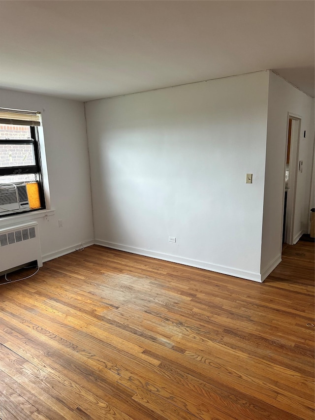 52-21 65th Pl Unit 6P, Maspeth, NY 11378 - spare room with baseboards, radiator, wood finished floors, and cooling unit