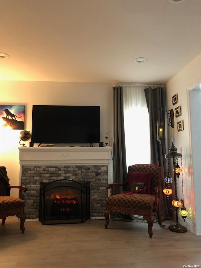 sitting room featuring hardwood / wood-style floors and a brick fireplace