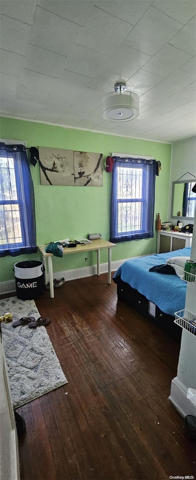 bedroom with dark hardwood / wood-style flooring