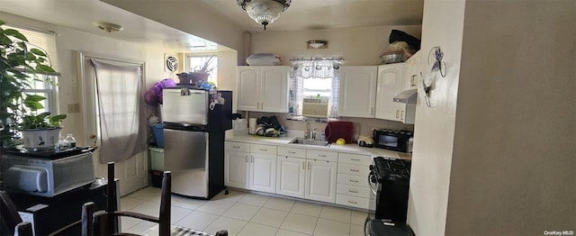 kitchen featuring white cabinets, exhaust hood, sink, and black appliances