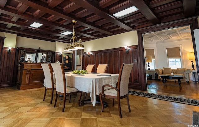 dining room with light parquet flooring, beam ceiling, and coffered ceiling