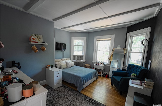 bedroom with hardwood / wood-style floors and radiator