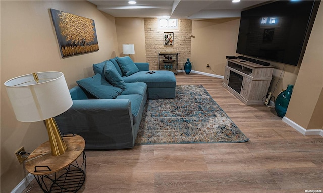 living room featuring light hardwood / wood-style floors and a brick fireplace