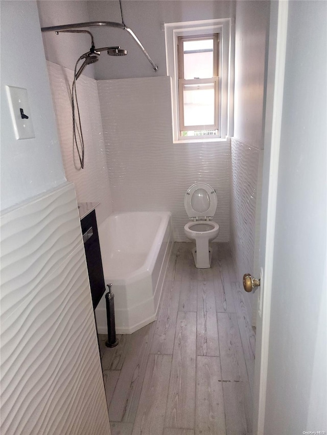 bathroom featuring hardwood / wood-style flooring, toilet, and tile walls