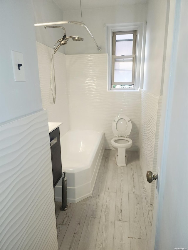 bathroom featuring vanity, wood-type flooring, tile walls, and toilet