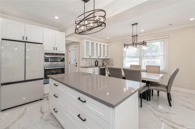 kitchen featuring pendant lighting, white cabinetry, a center island, and stainless steel appliances