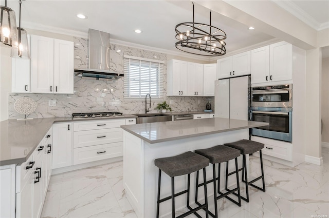 kitchen with white cabinets, sink, a kitchen island, and wall chimney range hood