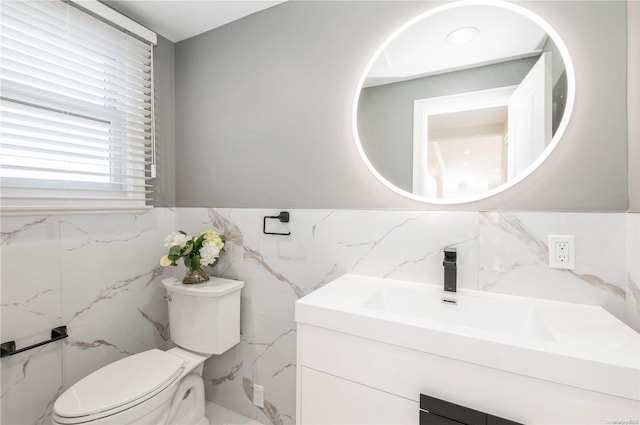 bathroom featuring vanity, tile walls, and toilet