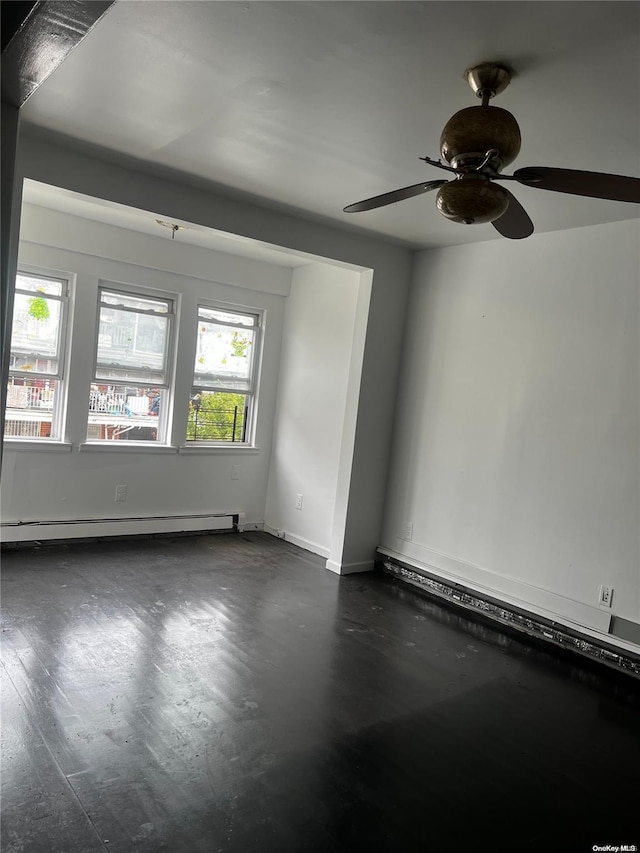 spare room featuring dark hardwood / wood-style floors, ceiling fan, and baseboard heating