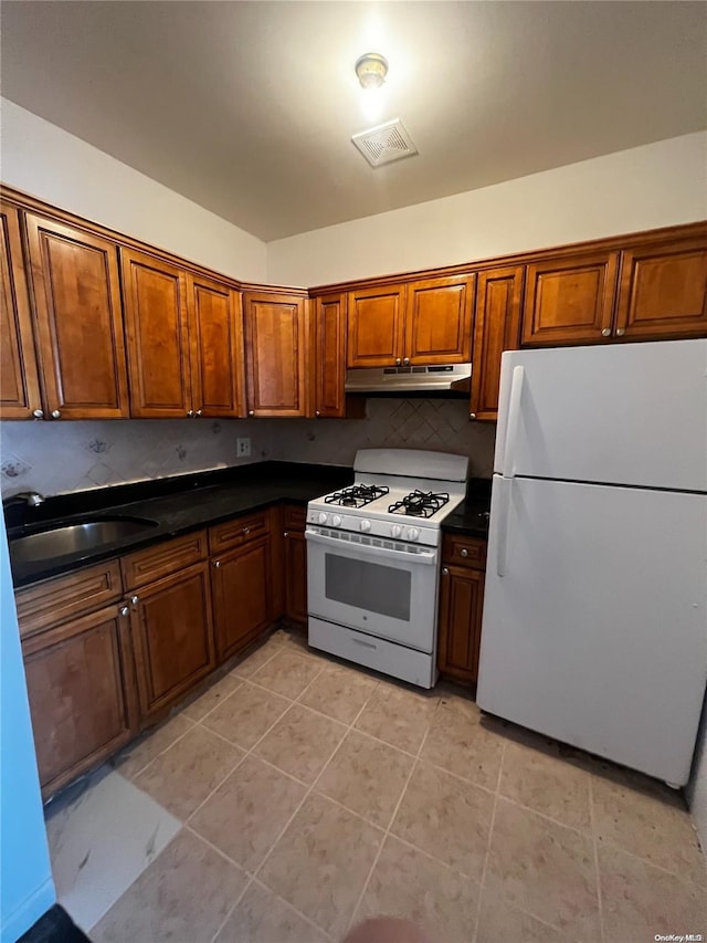 kitchen featuring decorative backsplash, light tile patterned floors, white appliances, and sink