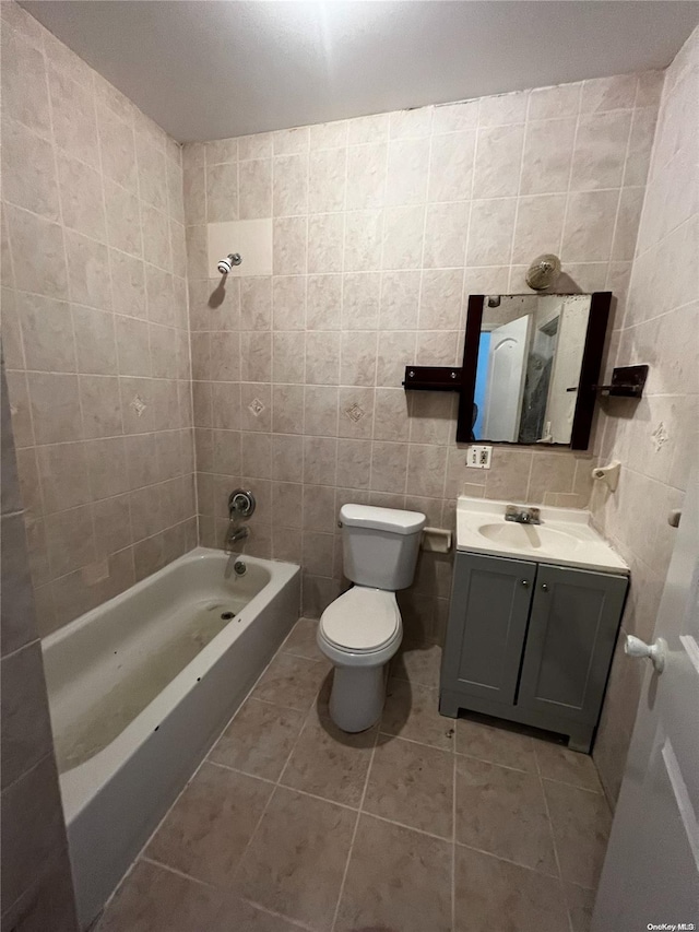 full bathroom with tile patterned flooring, toilet, and tile walls