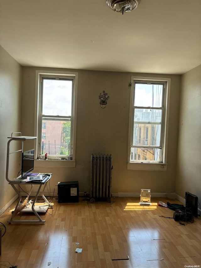 miscellaneous room with radiator heating unit and light hardwood / wood-style floors