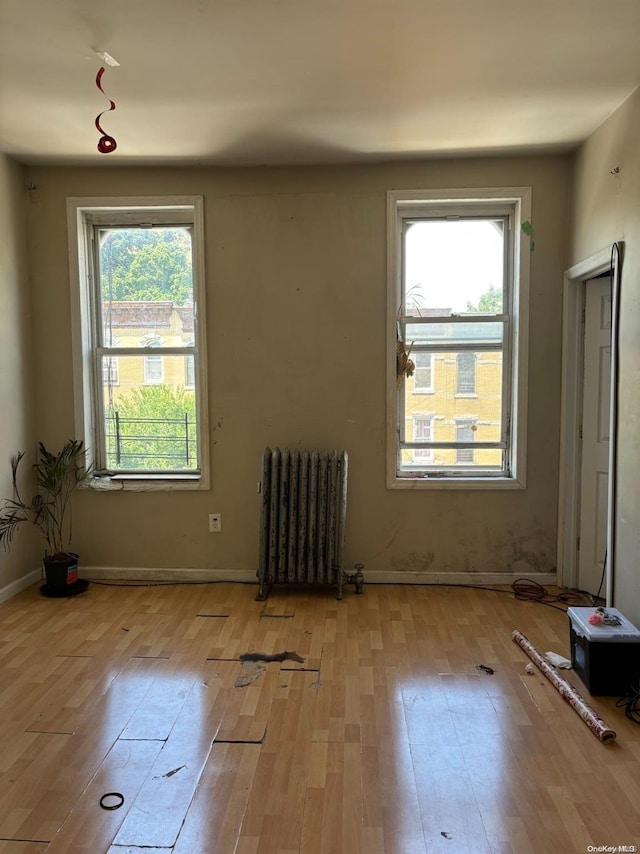 spare room featuring light hardwood / wood-style floors and radiator