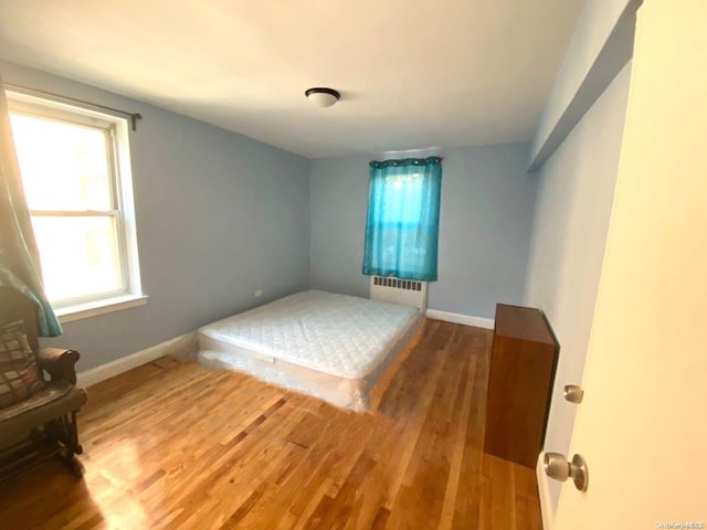 bedroom featuring wood-type flooring and radiator