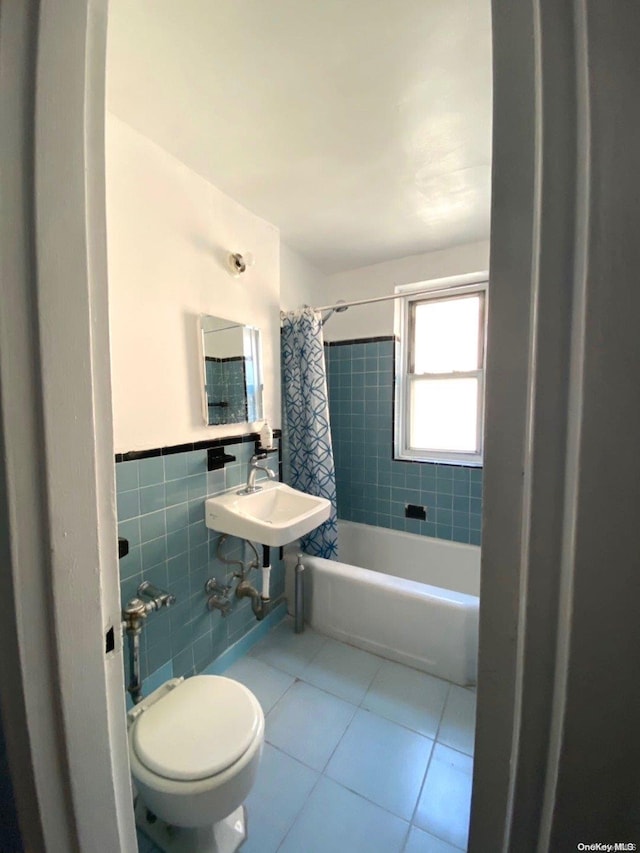 bathroom featuring shower / bath combo with shower curtain, tile patterned flooring, tile walls, and toilet