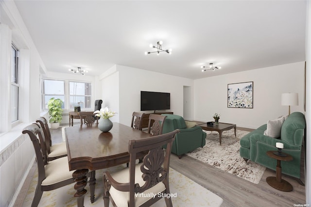 dining area featuring light hardwood / wood-style flooring and an inviting chandelier