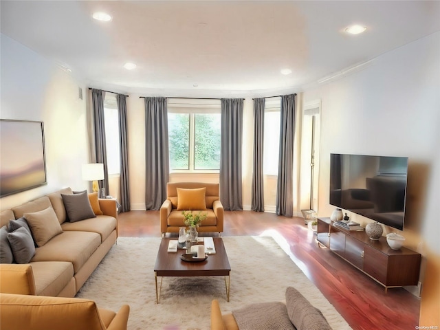 living room with recessed lighting, crown molding, and wood finished floors