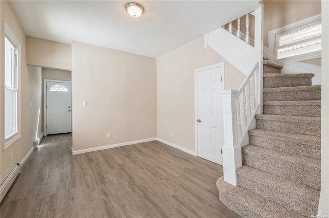 staircase featuring wood-type flooring and a baseboard radiator