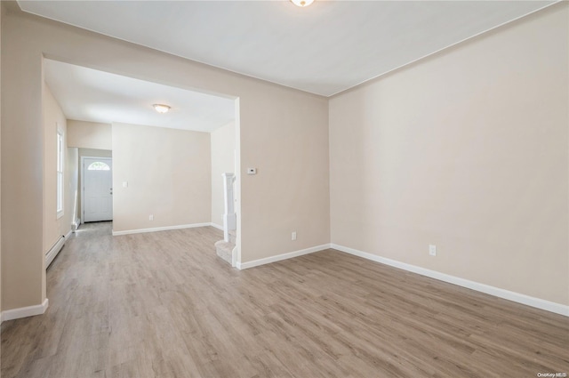 spare room featuring light hardwood / wood-style flooring and a baseboard heating unit