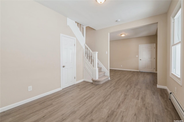 unfurnished room featuring light hardwood / wood-style flooring and a baseboard heating unit